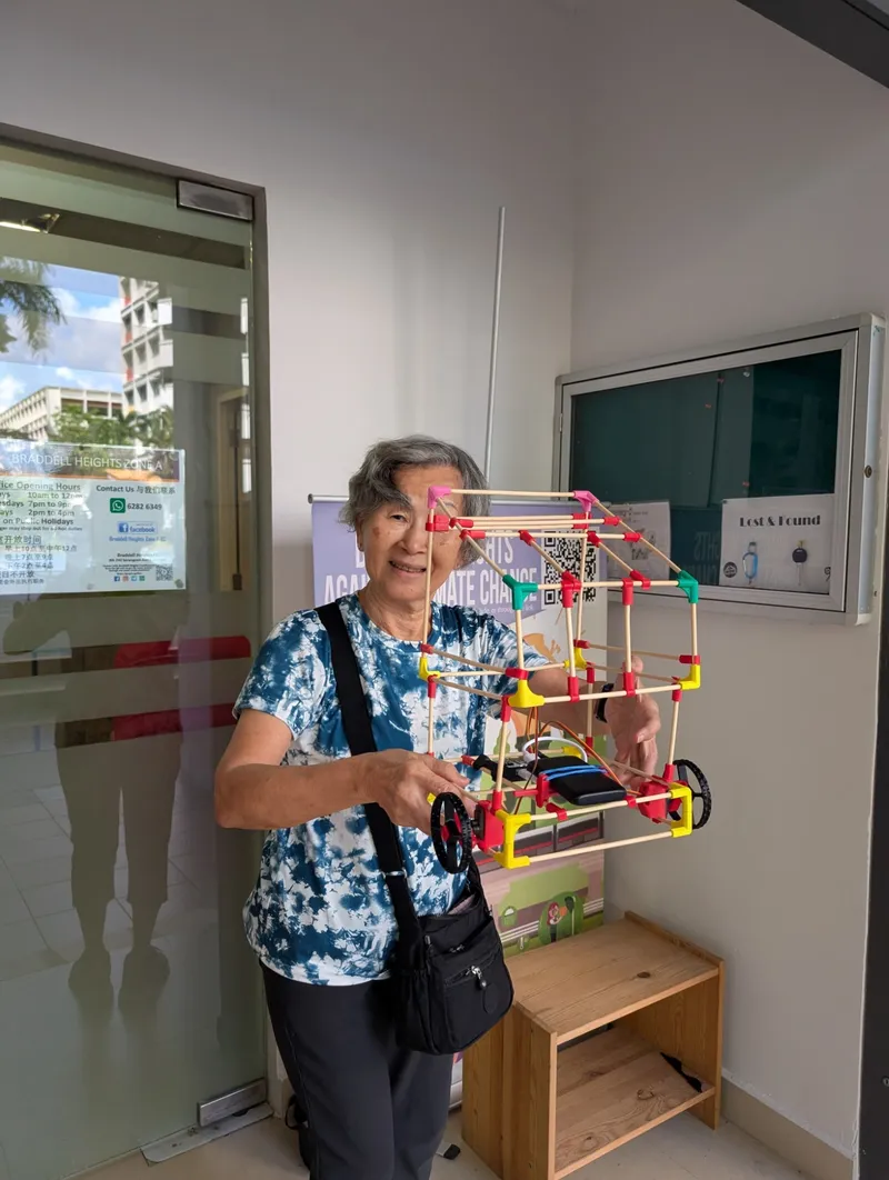 Proudly holding her chopstick house on wheels