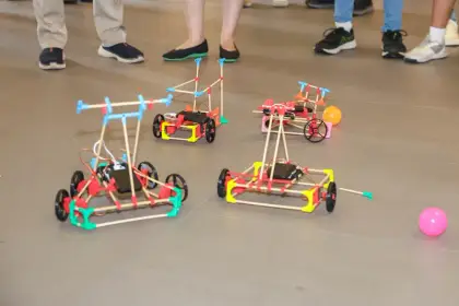 Two robot cars chase a ball