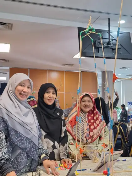 Teachers beside their tall structure