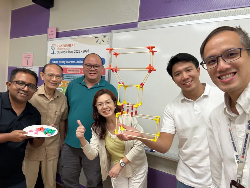 Cantonment Primary teachers holding up a chopstick tower