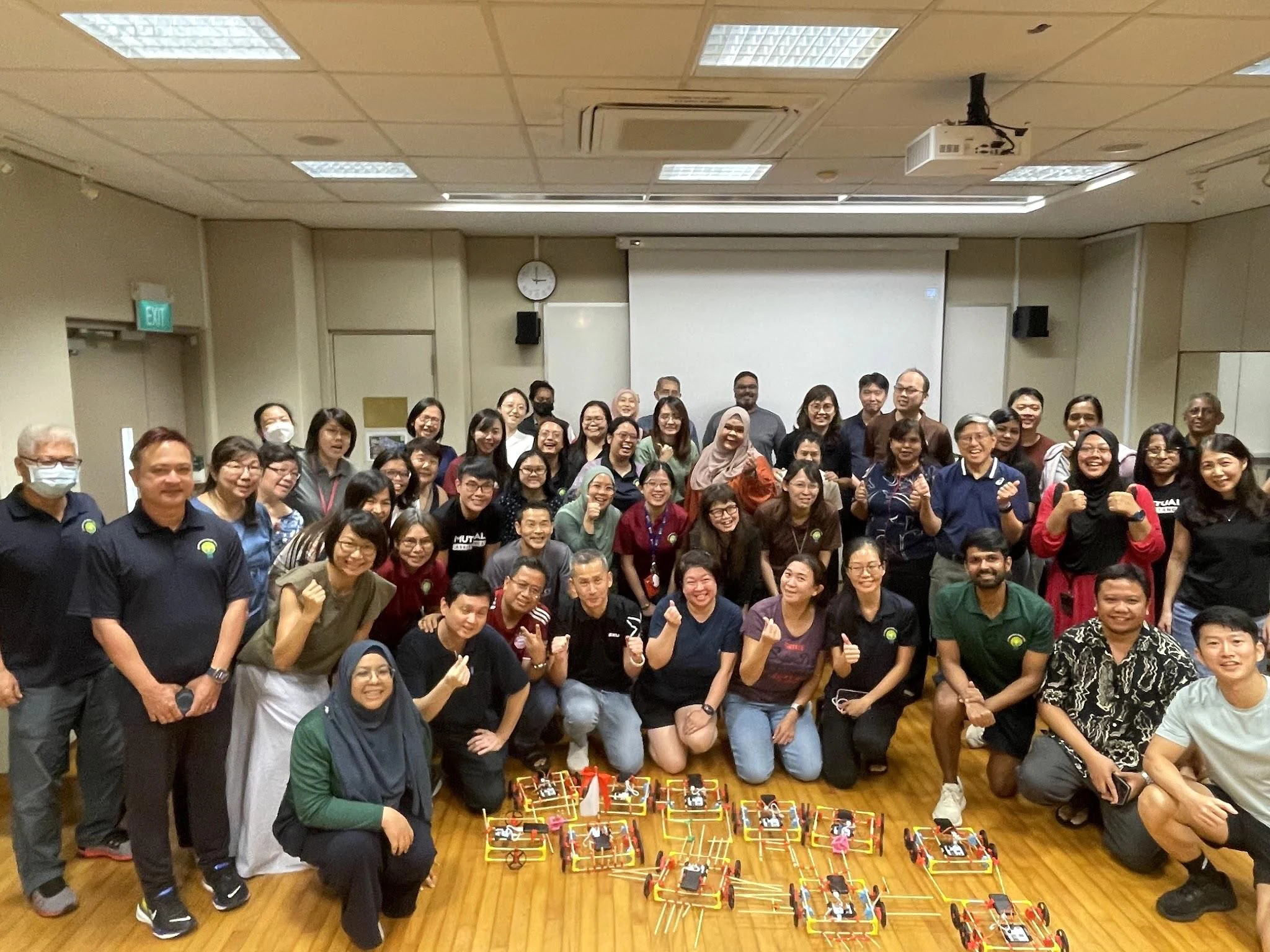 A whole hall of teachers with the builds they made laid out on the floor in front of them