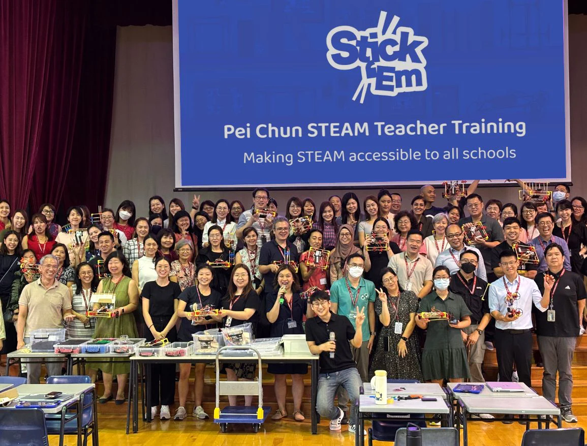 The Pei Chun Public School staff under a slide reading Pei Chun STEAM Teacher Training